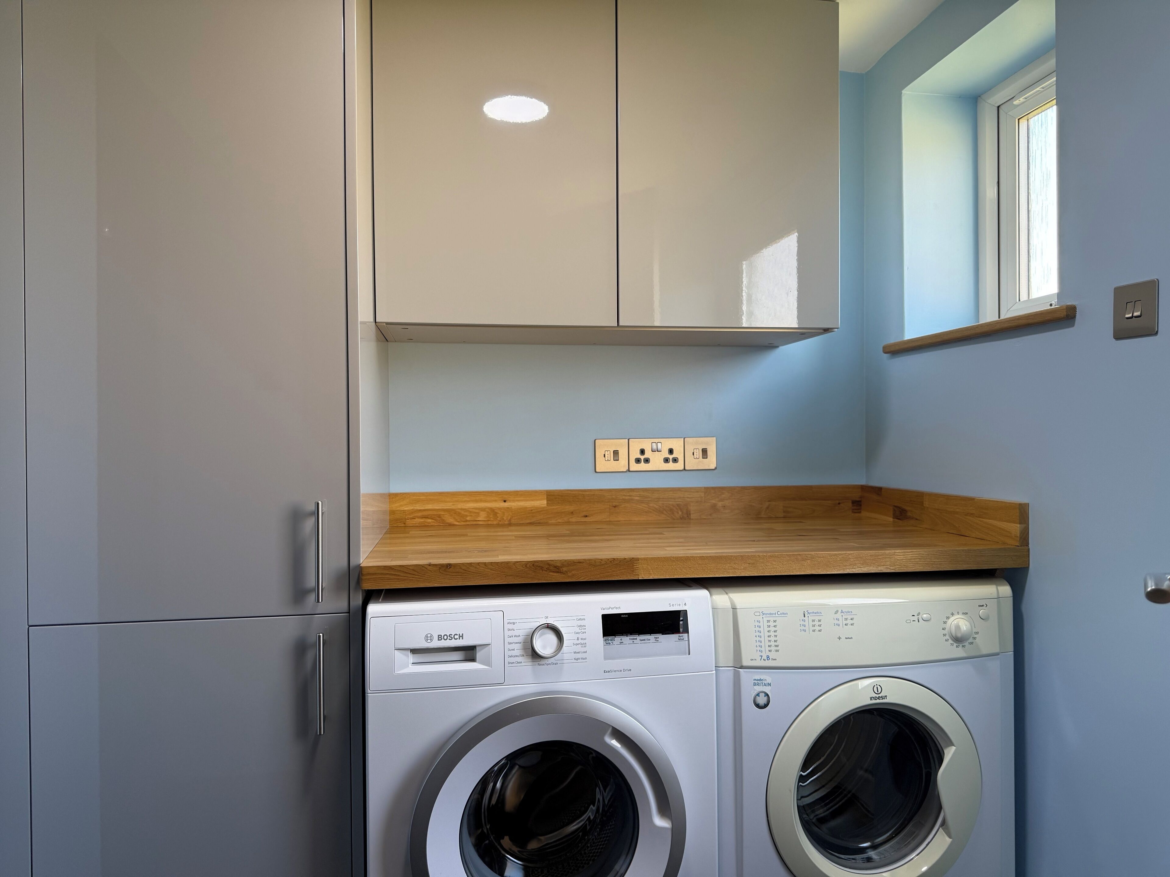 A compact laundry area with a Bosch washing machine and a Brita water softener.
