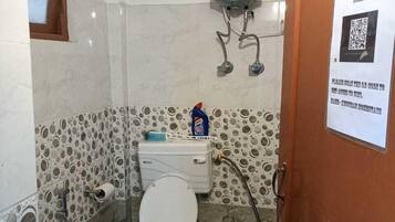 A bathroom with a toilet, bidet, and a water heater.
