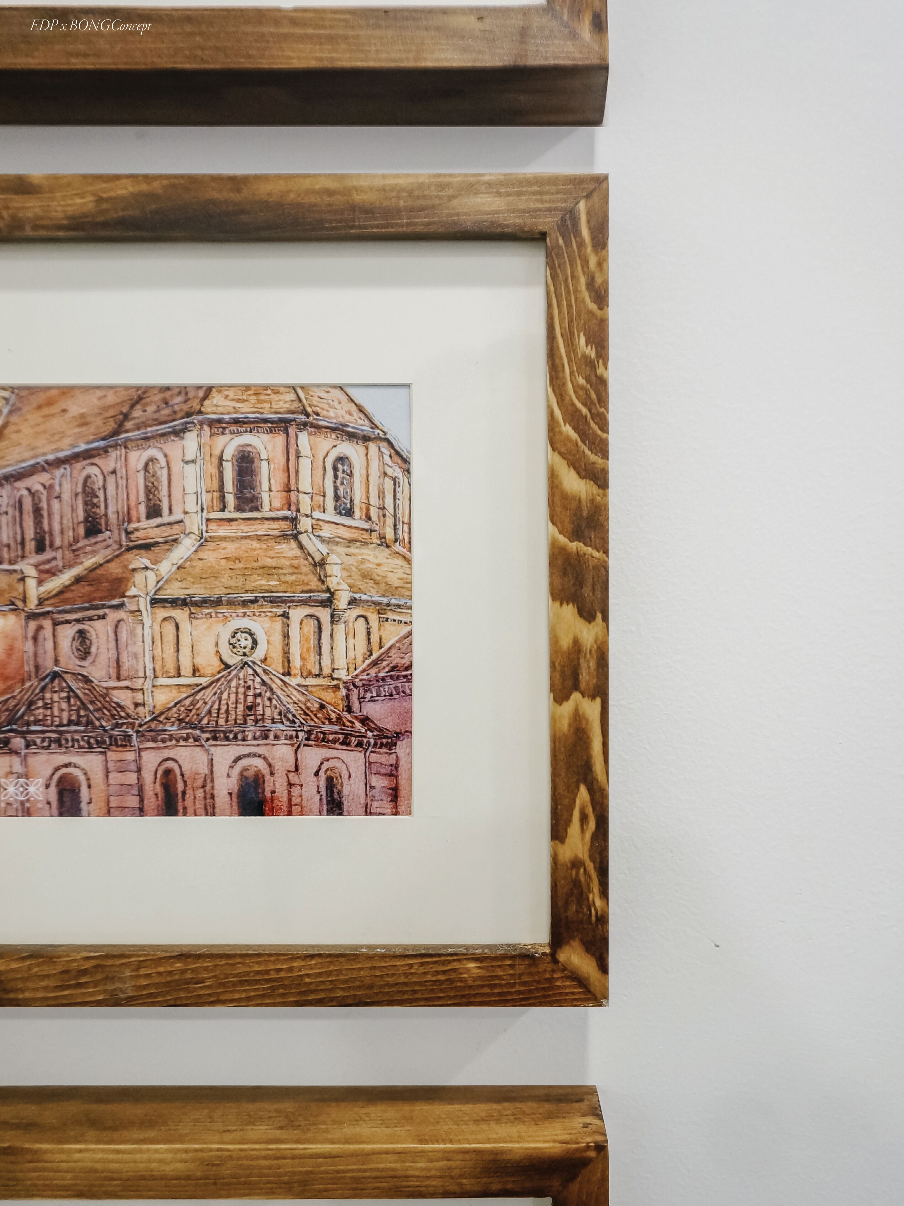 A framed artwork of a building with arched windows and a dome.