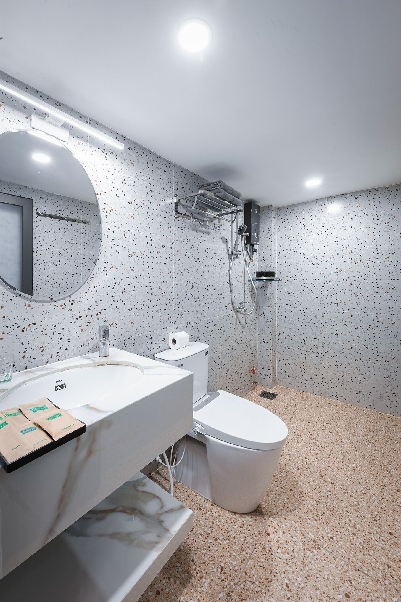 A modern bathroom with a white sink, toilet, and shower.