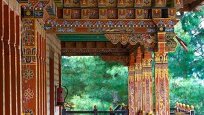 An intricately decorated interior with ornate pillars and a wooden staircase leading to a balcony. - Hotel Jakar View (Bumthang)