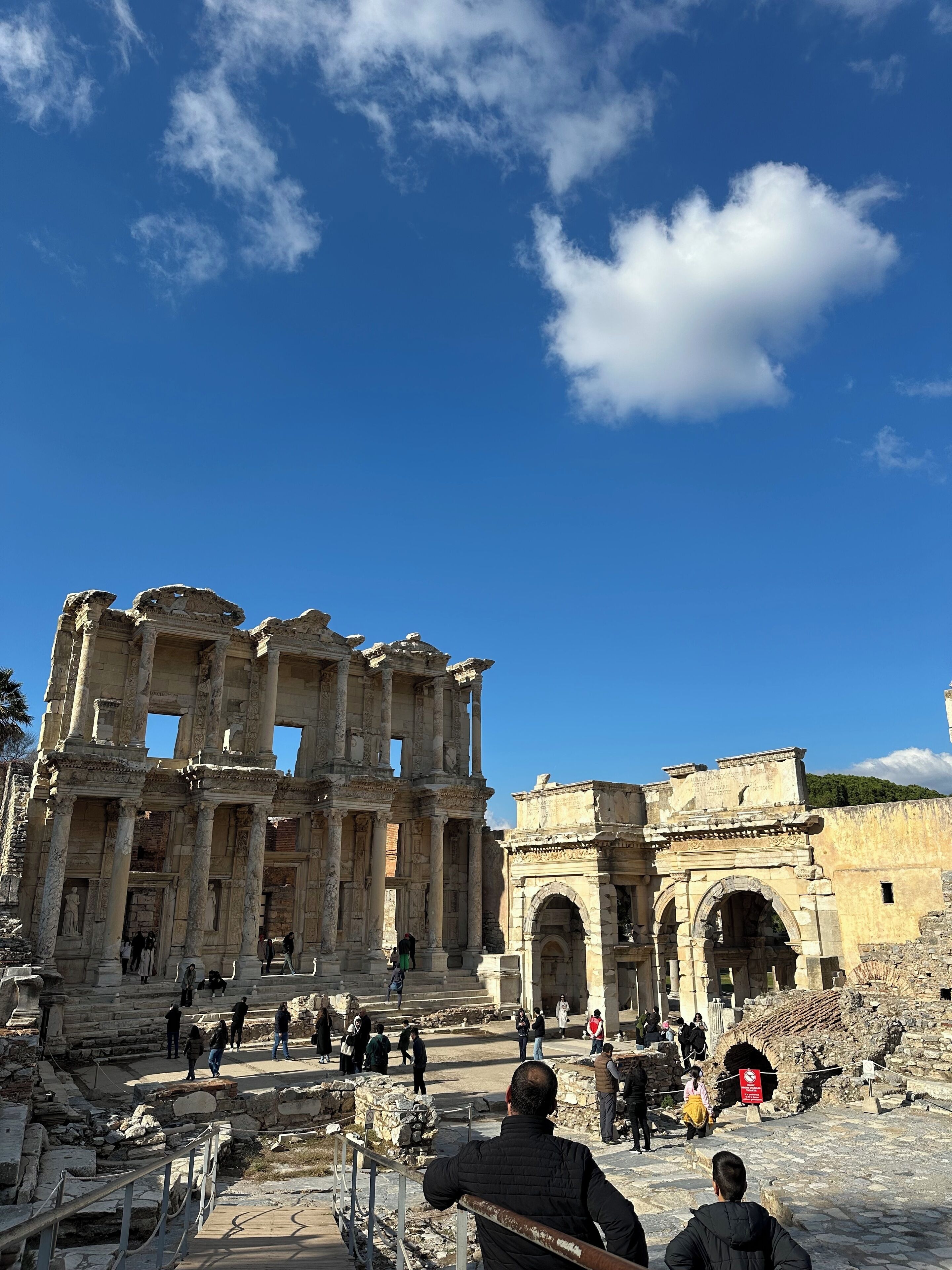 Des ruines antiques, avec des colonnes et des arches, entourées de visiteurs.