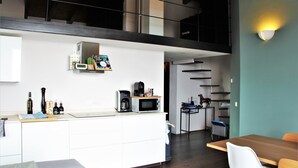 A modern kitchen with a microwave, coffee maker, and wine bottles on the counter. - CasaFranka Lake Garda (Toscolano Maderno). Quiet location and exceptional view (Toscolano Maderno)