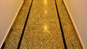A hallway with a polished floor, doors on both sides, and a door at the end. - Aangan Palace (Udaipur)