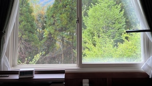 A room with a large window offering a view of a forest and mountains. - Private Room Guesthouse ORSA MINAMIASO (Minamiaso)