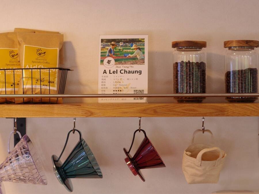 A shelf with bags of coffee, jars of spices, and a menu.
