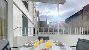 A balcony with a table set for breakfast, including croissants and orange juice, overlooking a cityscape. - Cityzen Funchal by Atlantic Holiday (Funchal)