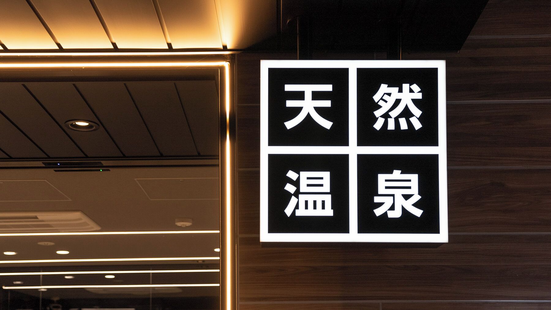 A sign with Chinese characters on a wooden wall.