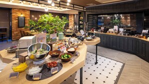 Ein Bereich mit einem Buffet und verschiedenen Speisen sowie einer Kaffeestation.