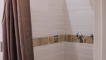 Chuveiro, toalhas de banho, papel higiênico