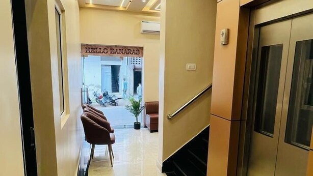 A hotel corridor with a marble floor, a reception desk, and an elevator. - Hello Banaras (Varanasi)