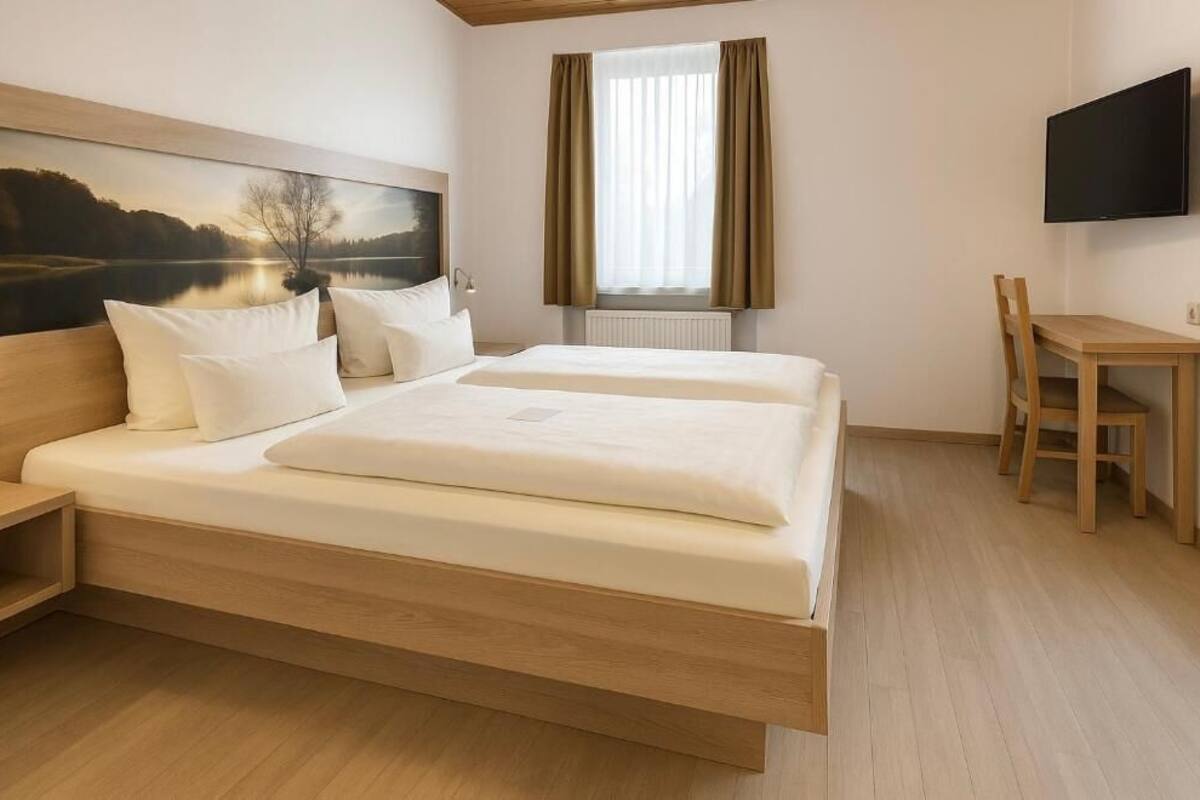 Ein modernes Schlafzimmer mit einem großen Bett, einem Schreibtisch und einem Fernseher.