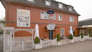 Ein Hotel mit einem Schild für 'Hotel Schmida-Mönnikes' und einer Vitrine.