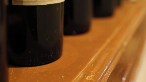 Várias garrafas de vinho com etiquetas dispostas sobre uma superfície de madeira.