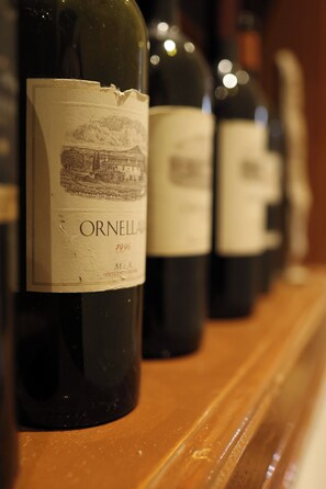 Una hilera de botellas de vino con etiquetas, una de ellas muestra claramente 'ORNELLA 1996'.