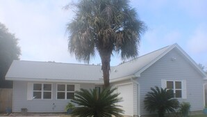 A single-story house with a sloped roof, a front porch, and a well-maintained lawn. - Navarre Beach Escape-Pet & Family Friendly (Navarre)
