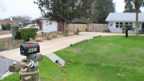 A mailbox with a number 6657, a wooden post, and a grassy yard with a house in the background. - Navarre Beach Escape-Pet & Family Friendly (Navarre)
