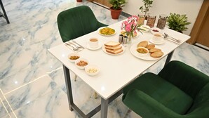 Une table à manger avec des assiettes remplies de nourriture, des tasses et des couverts.