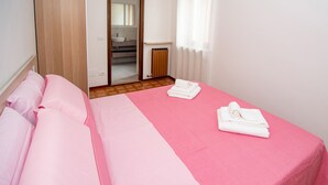 Ein Hotelzimmer mit einem Bett, einem durchgegangenen Tür sichtbaren Badezimmer und einem Heizkörper.