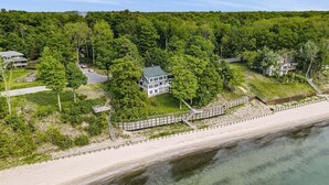 Une propriété située sur la côte, comprenant une grande maison, une plage et une zone boisée.