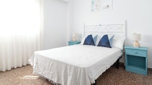 Ein ordentlich eingerichtetes Schlafzimmer mit einem Bett, zwei Nachttischen und einem Fenster mit Vorhängen.
