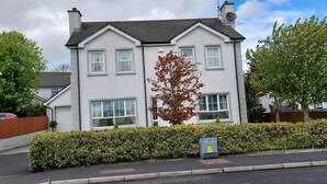 A two-story house with a white exterior, multiple windows, and a chimney. - Carndonagh - 3-bedrooms - Sleeps 6/7 - Garden (Carndonagh)