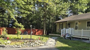 A house with a front porch, a welcome sign, and a mailbox. - Elma-Vista Spacious 3-bedroom apartment with WiFi and AC in charming Ellsworth (Ellsworth)