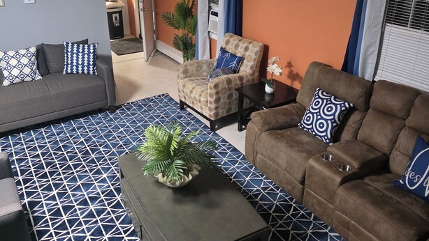 A living room with a sofa, armchairs, a coffee table, and patterned rugs. - Elma-Vista Spacious 3-bedroom apartment with WiFi and AC in charming Ellsworth (Ellsworth)