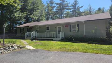 A single-story house with a front porch, a small front yard, and a driveway.
