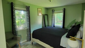 A bedroom with a bed, a desk, and a chair. There are two windows with curtains. - Elma-Vista Spacious 3-bedroom apartment with WiFi and AC in charming Ellsworth (Ellsworth)
