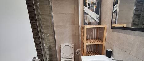 Une petite salle de bain comprenant des toilettes, une baignoire et un espace douche.