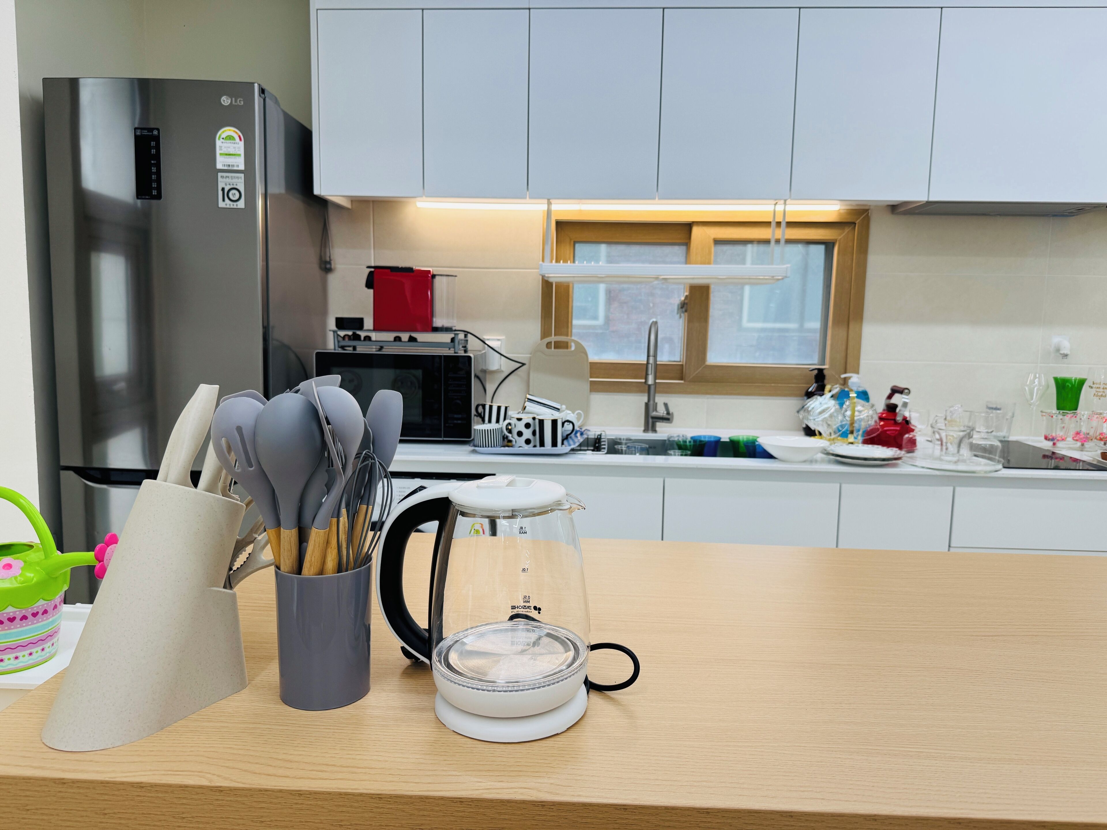 A modern kitchen with stainless steel appliances, a microwave, and a sink.