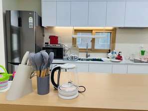 A modern kitchen with stainless steel appliances, a microwave, and a sink. - 사Atelier Seongsu Riverside Loft Cherry Blossom Road Han River airport bus (Seoul)