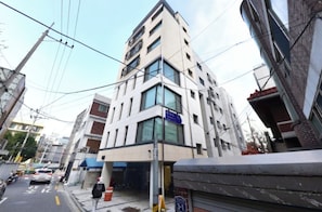 A multi-story building with a blue sign indicating a business on the ground floor. - 사Atelier Seongsu Riverside Loft Cherry Blossom Road Han River airport bus (Seoul)