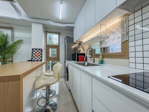 Una cocina moderna con barra, horno empotrado y ventana que ofrece luz natural.