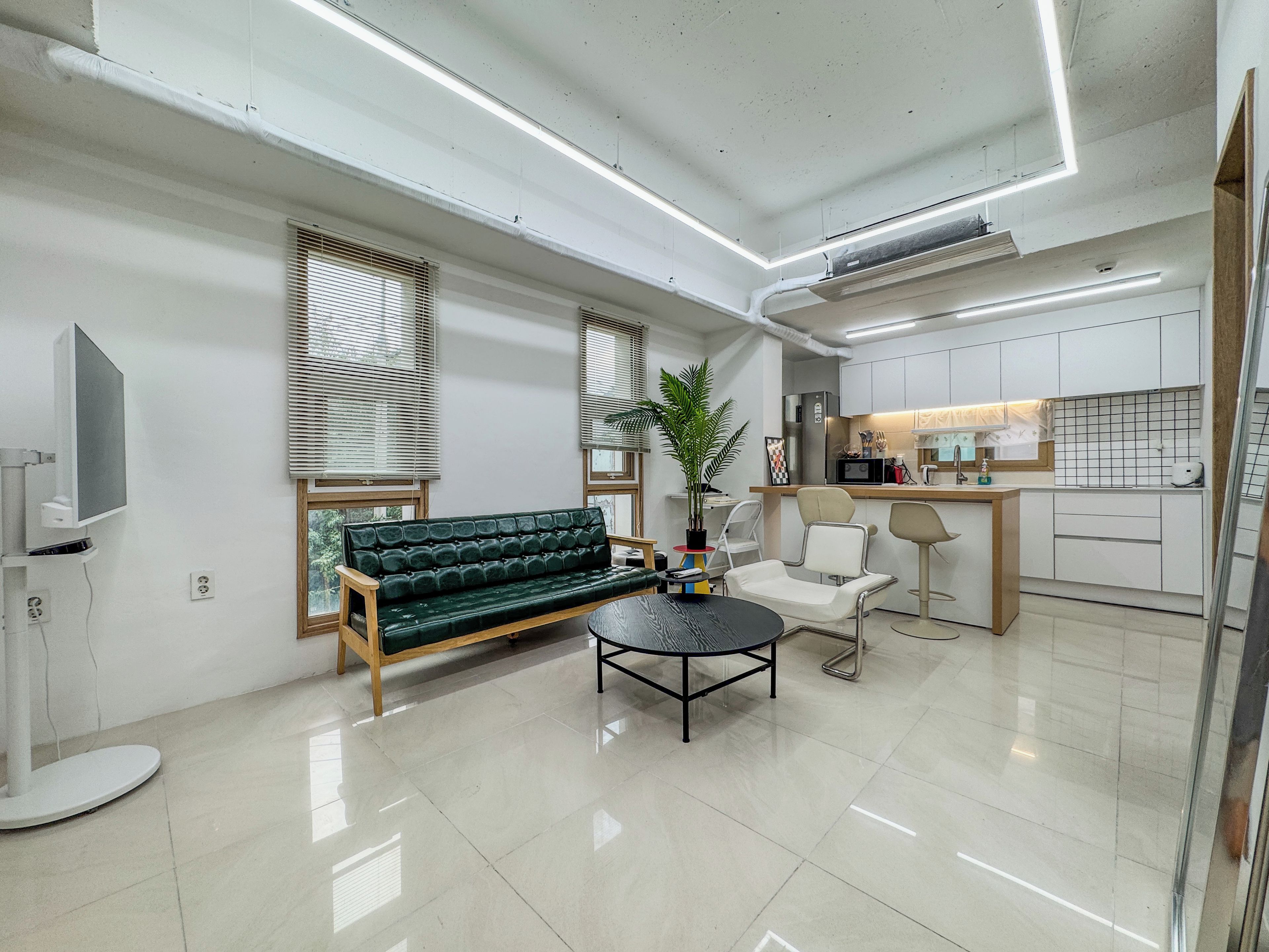 A modern living room with a sofa, a coffee table, and a TV.