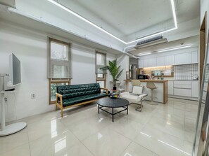 A modern living room with a sofa, a coffee table, and a TV. - 사Atelier Seongsu Riverside Loft Cherry Blossom Road Han River airport bus (Seoul)