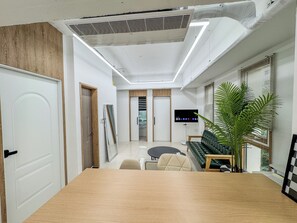 Un interior moderno con una mesa de conferencias de madera, un sofá y un televisor.