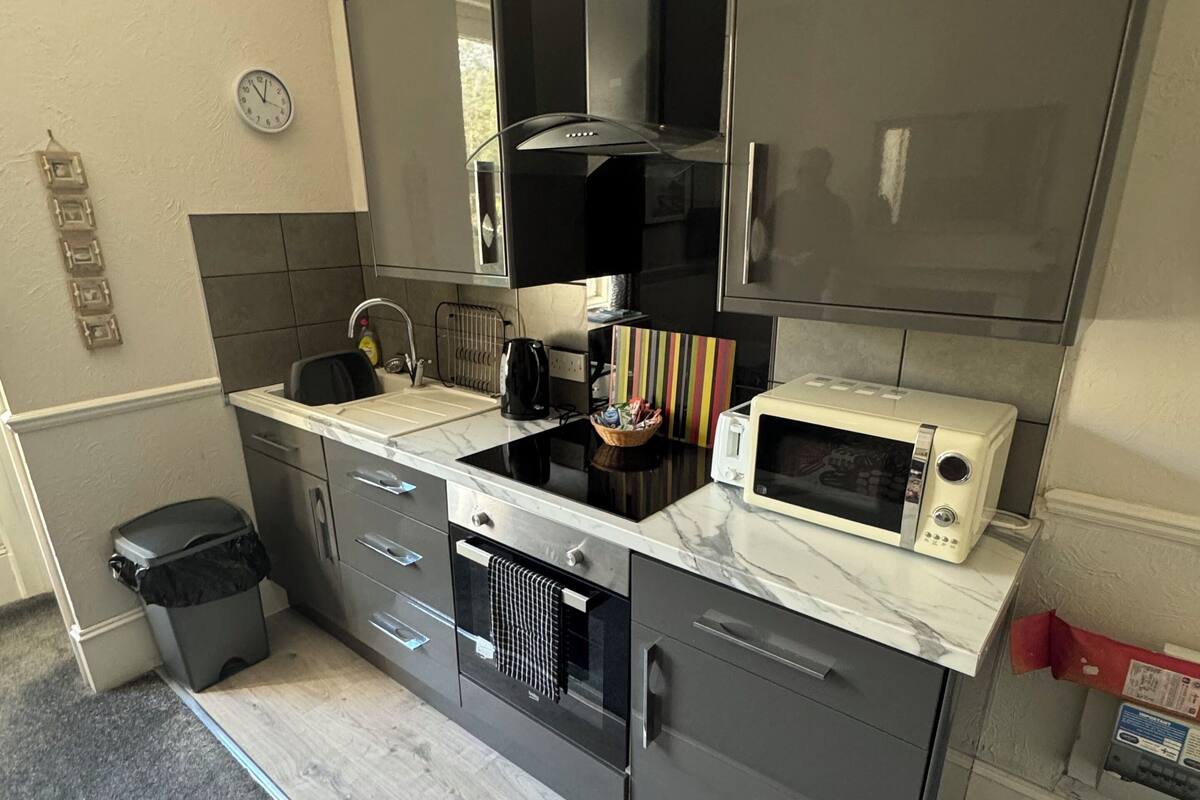 Une cuisine moderne équipée d’un four à micro-ondes, d’une cuisinière et de placards.