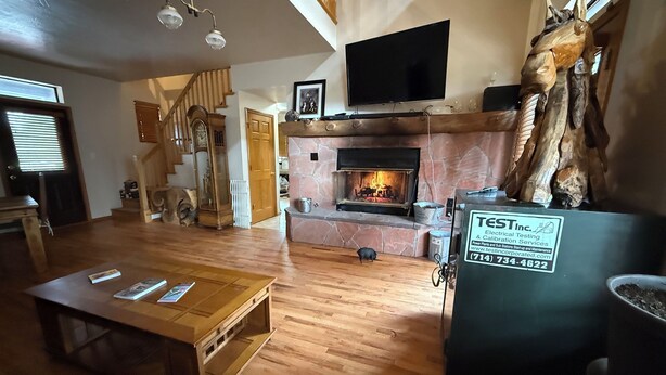 Ein Wohnzimmer mit Kamin, Holzmöbeln, einem Fernseher und einer Giraffenskulptur.