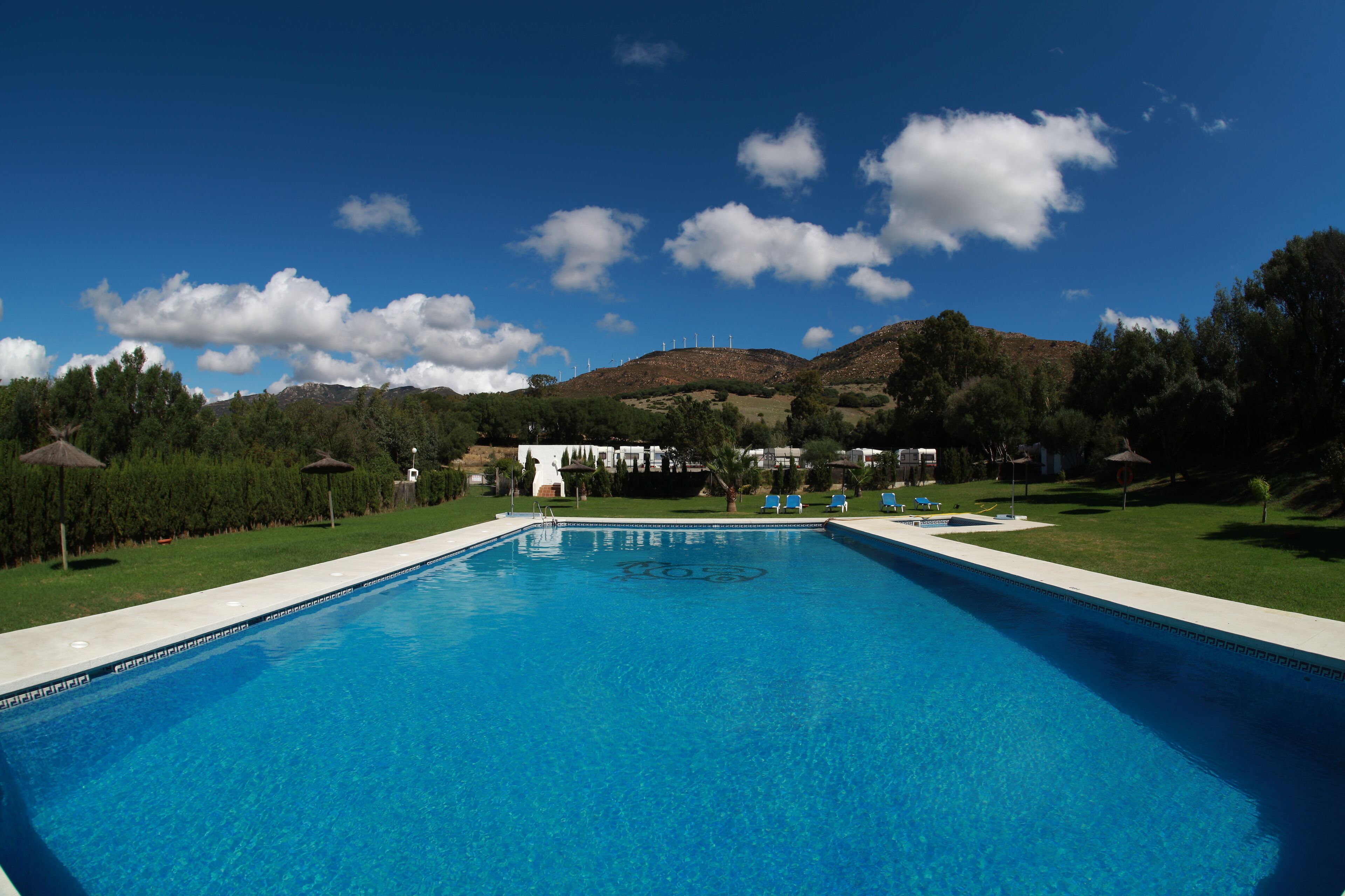 Una piscina al aire libre de temporada, sombrillas
