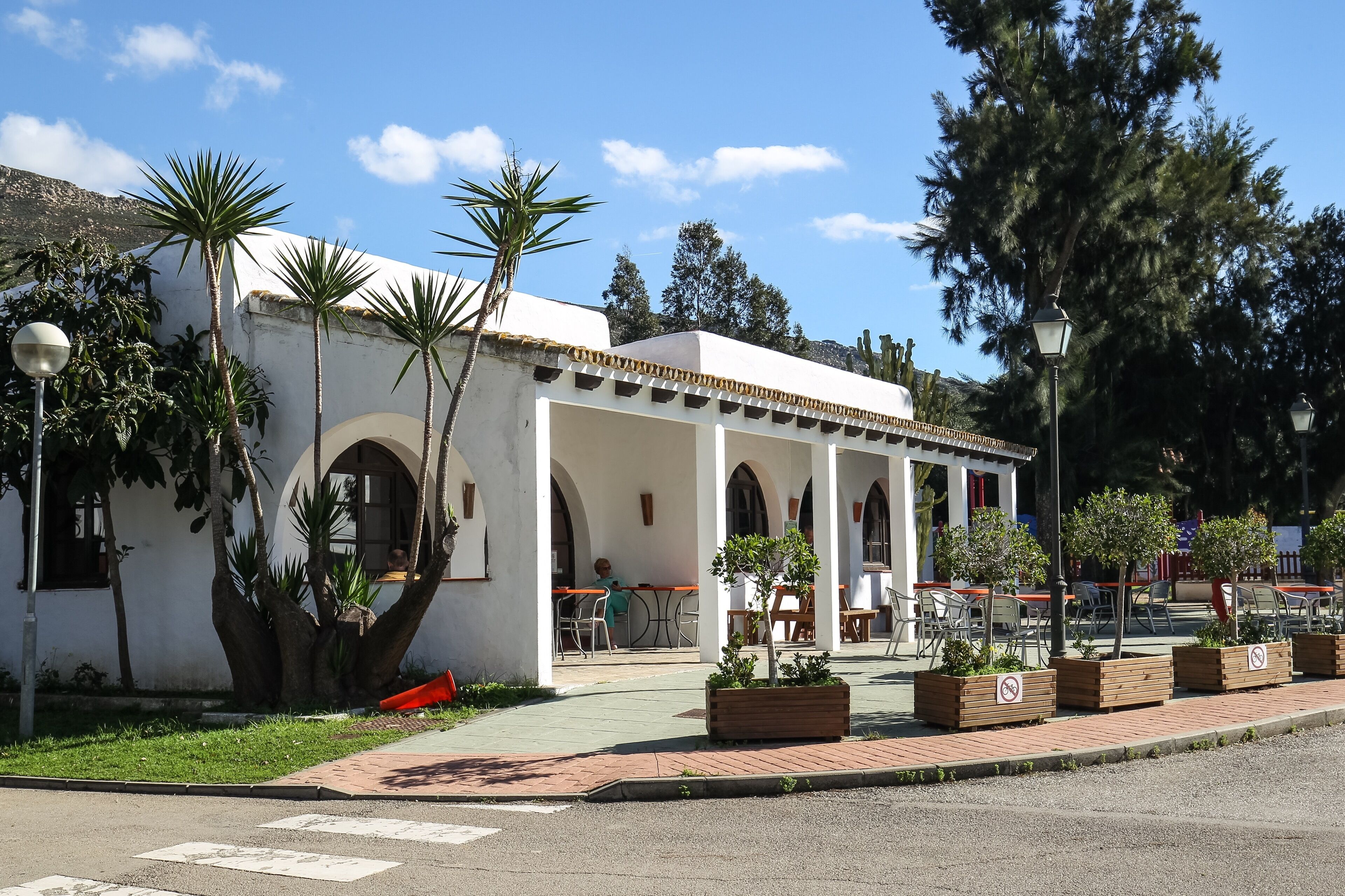 A white building with arched windows and a covered patio area.