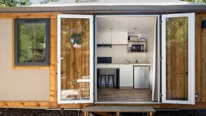A compact mobile home with an open door revealing a kitchenette, a dining area, and a small seating space. - TAIGA Tarifa Valdevaqueros (Tarifa)