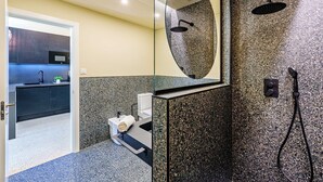 A modern bathroom with a granite shower wall, a large mirror, and a separate sink area. - Sunset Malaga Apartments - WIDE 1+2+3 (Málaga)