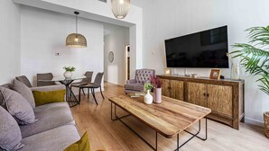 A modern living room with a sofa, dining table, and TV.