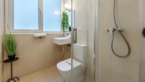 Ein Badezimmer mit Toilette, Waschbecken und Dusche.