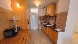 A compact kitchen with wooden cabinets, a countertop, and basic appliances.