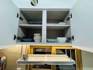 A kitchen with a built-in shelf unit containing bowls and plates. - 삼Atelier Seongsu Riverside Loft Cherry Blossom Road Han River airport bus (Seoul)