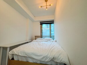 A bedroom with a bed, a window, and a ceiling light fixture. - 삼Atelier Seongsu Riverside Loft Cherry Blossom Road Han River airport bus (Seoul)