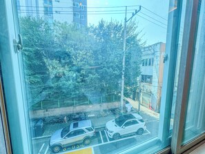 A parking area with multiple cars, a bicycle, and a pedestrian walkway. - 삼Atelier Seongsu Riverside Loft Cherry Blossom Road Han River airport bus (Seoul)